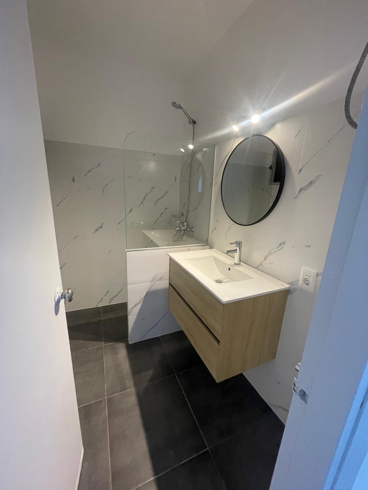 Baño reformado con ducha, mampara de vidrio, revestimientos y mueble flotante